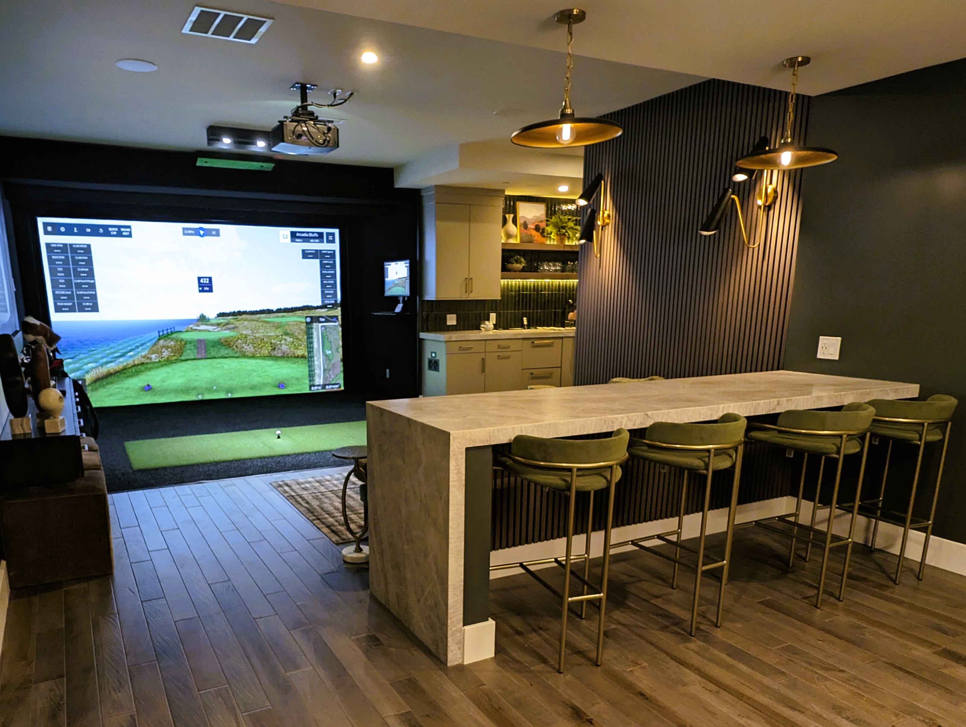 Custom golf simulator with accent walls, bar area, and kitchen.