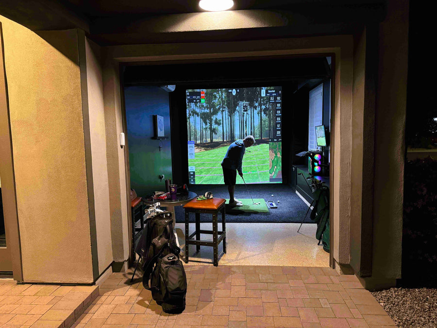 a golfer playing golf in a home simulator