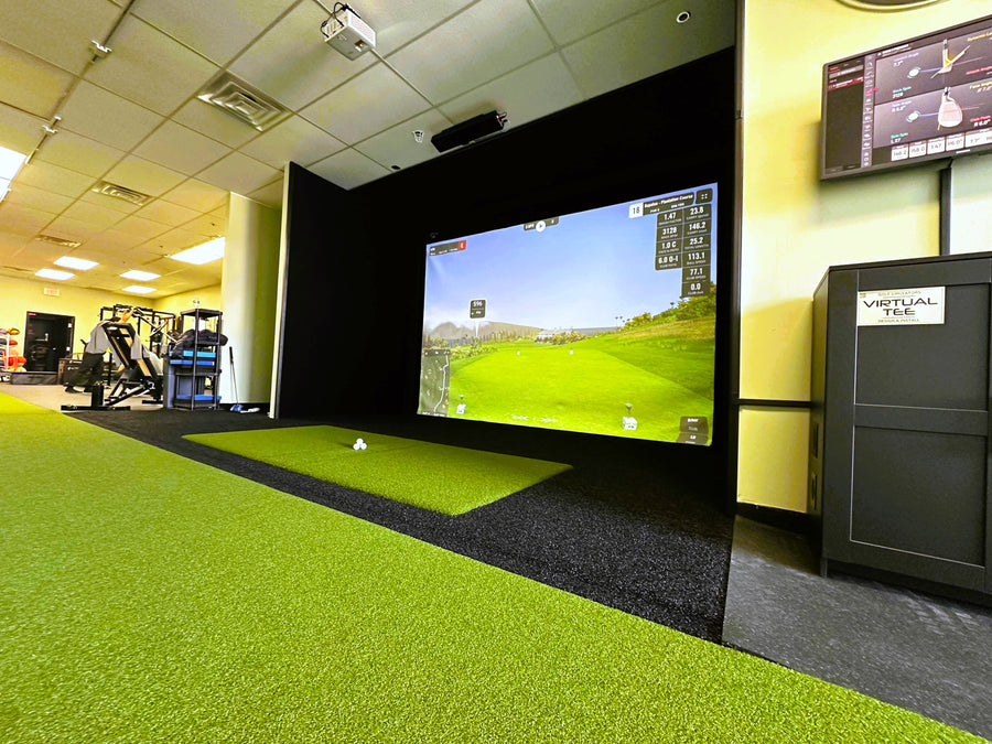 A commercial golf simulator showing a gym to the side.