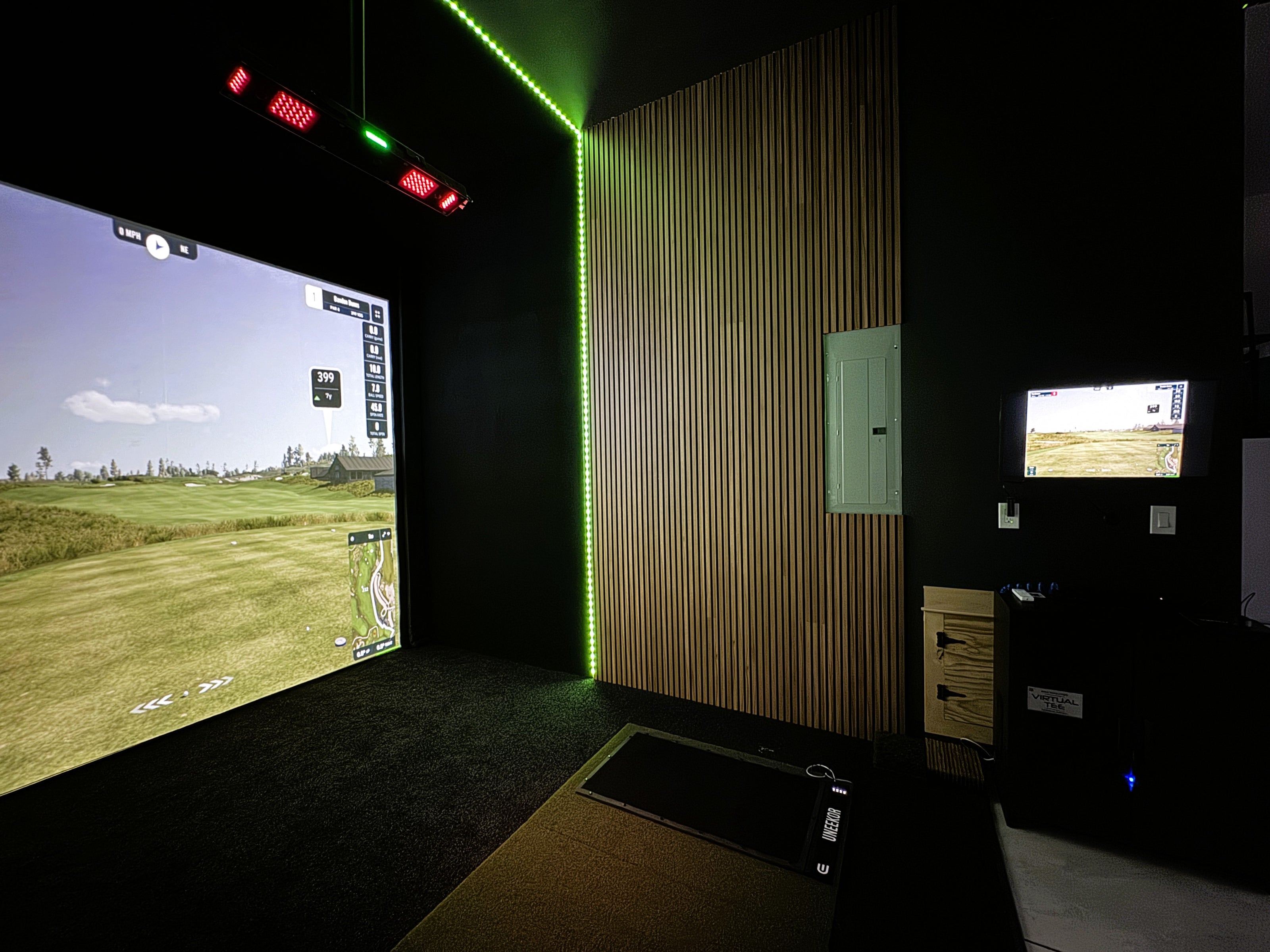 A custom garage simulator in Eugene, with an accent wall and black turf.