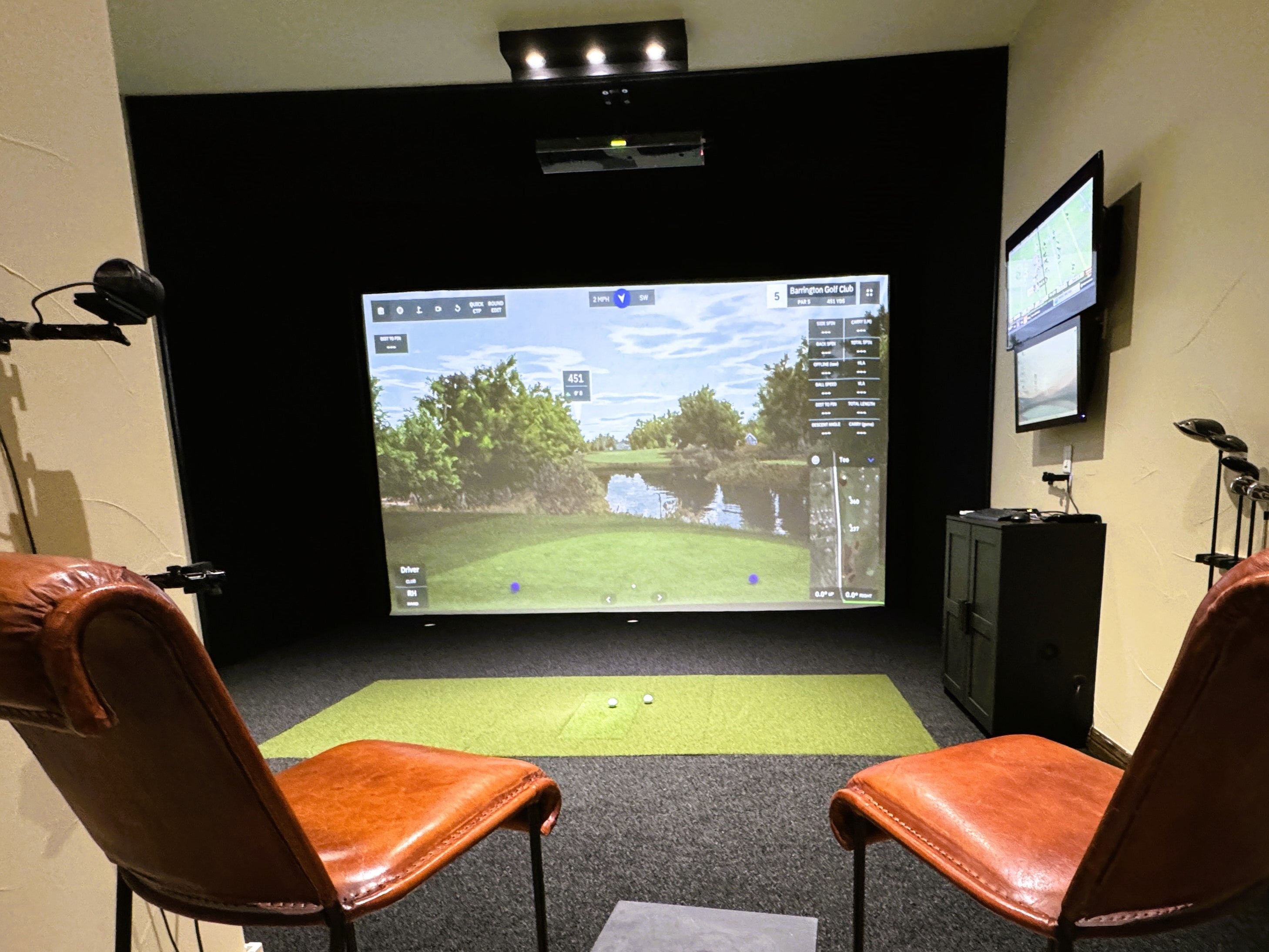 Custom golf simulator with black turf and custom screen system.