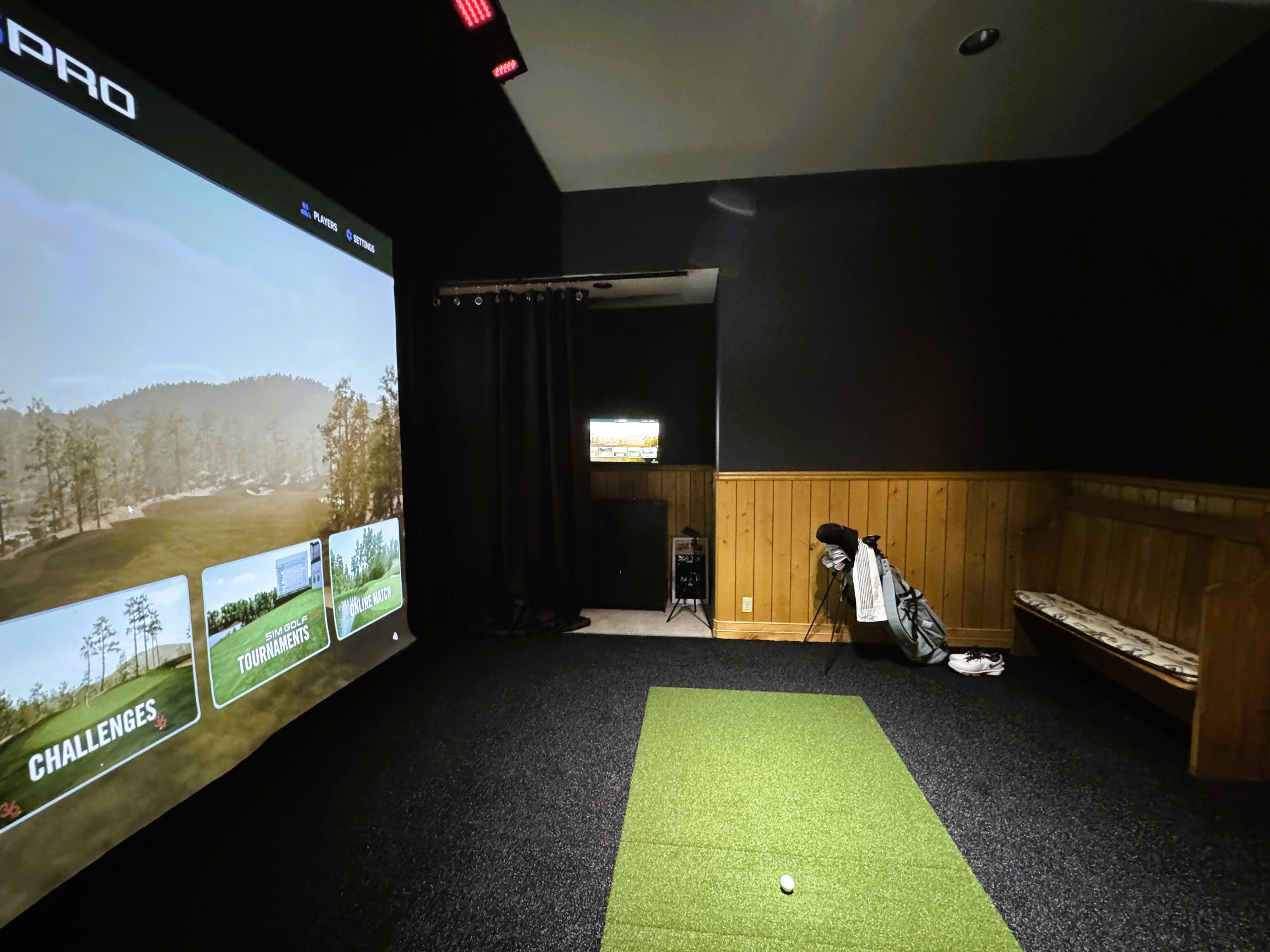 Custom home golf simulator in Bend, featuring a custom screen and black turf.