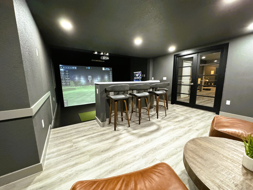 Custom golf simulator with bar and sitting area featuring the Uneekor EYE XO launch monitor.