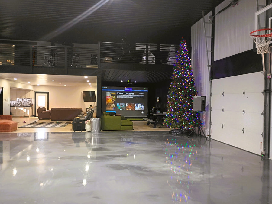 Golf simulator room with a Christmas tree and a large screen TV.