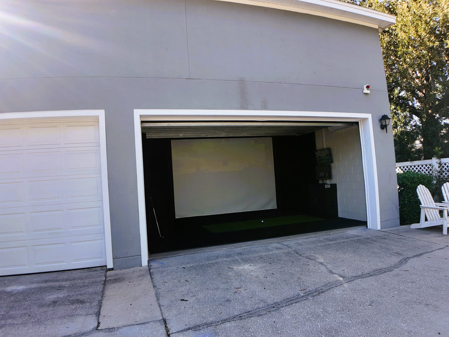 Garage with a golf simulator.