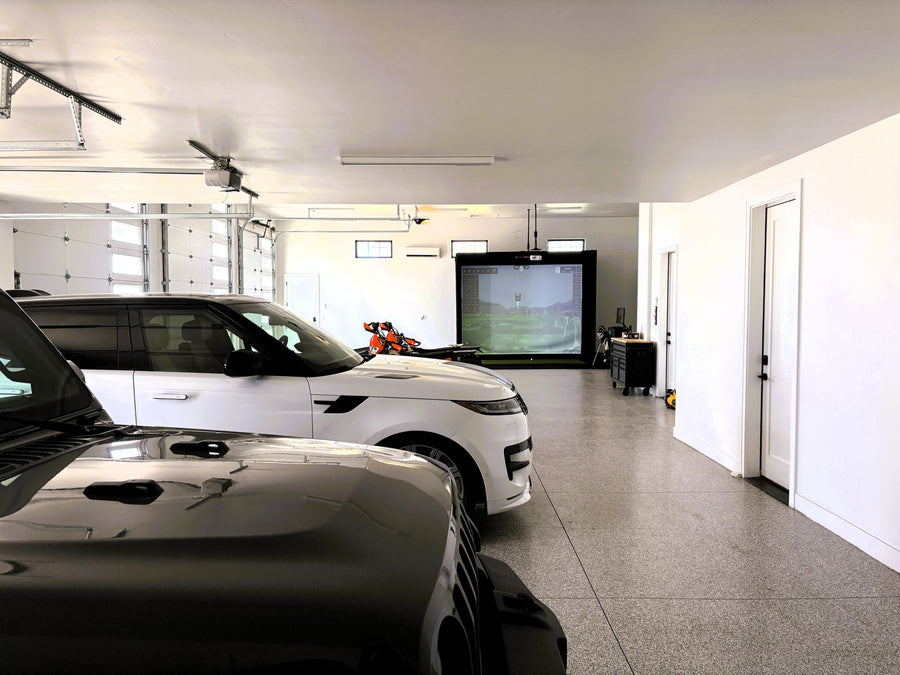 Modern garage with cars and a golf simulator in the background