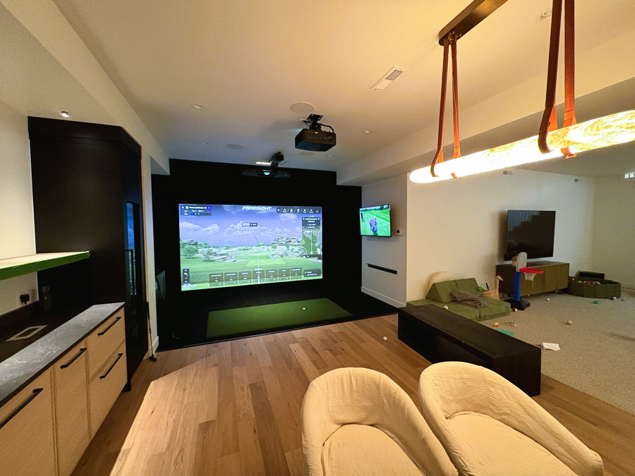 Golf simulator with a large screen displaying a golf simulation game.