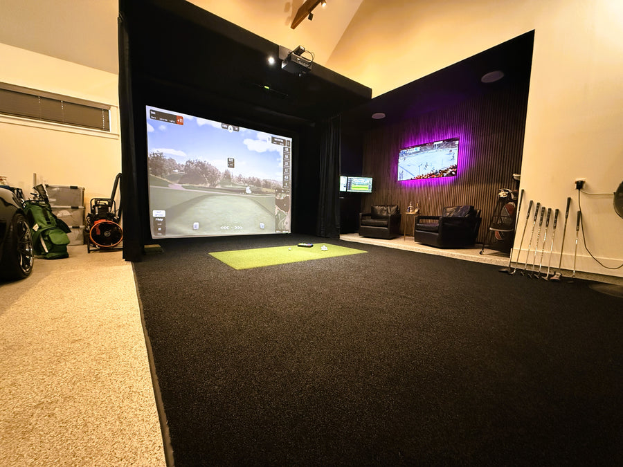 Golf simulator room with multiple screens displaying different games, surrounded by gaming equipment.