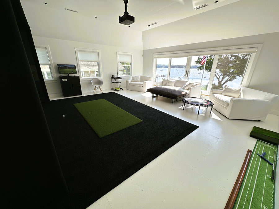 Golf simulator with a green and black indoor putting green