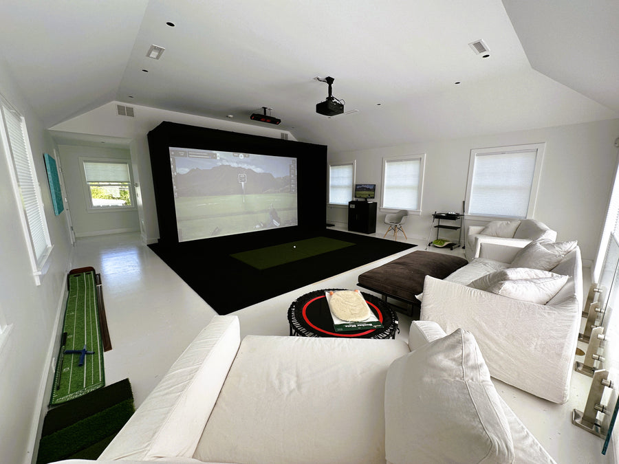 Modern indoor golf simulator with large screen, comfortable seating, and sports-themed decor.