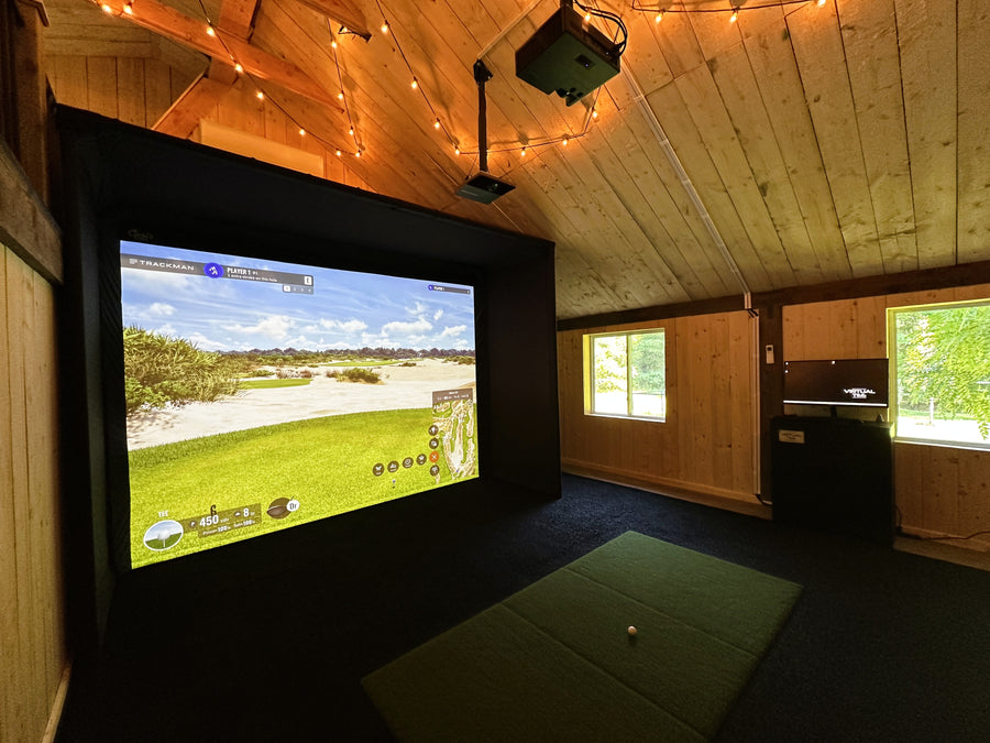 Barn golf simulator setup in a room with wooden walls and ceiling.