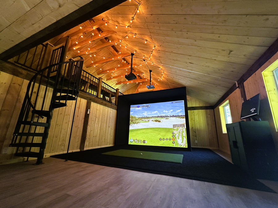 Barn golf simulator setup with screen and projector in a wooden room.