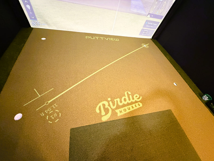 PuttView golf practice mat with Birdie House logo in a golf simulator.