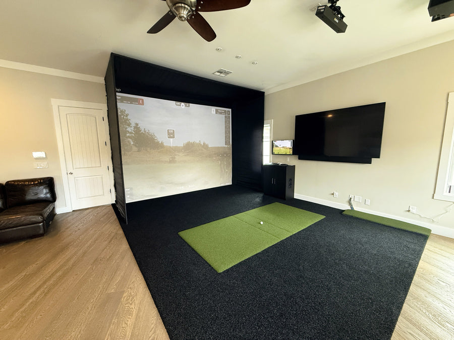 Golf simulator setup in a home entertainment room with a screen displaying a golf course.