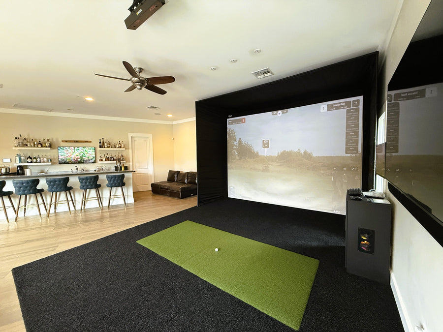 Golf simulator setup in a home entertainment room with a screen displaying a golf course.