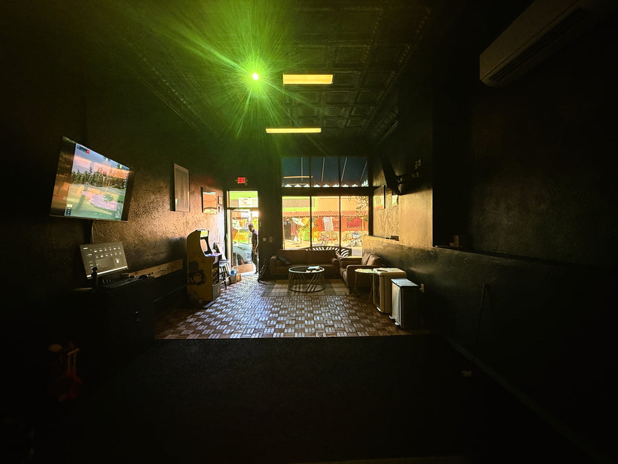 Golf simulator, surrounded by furniture and decor.
