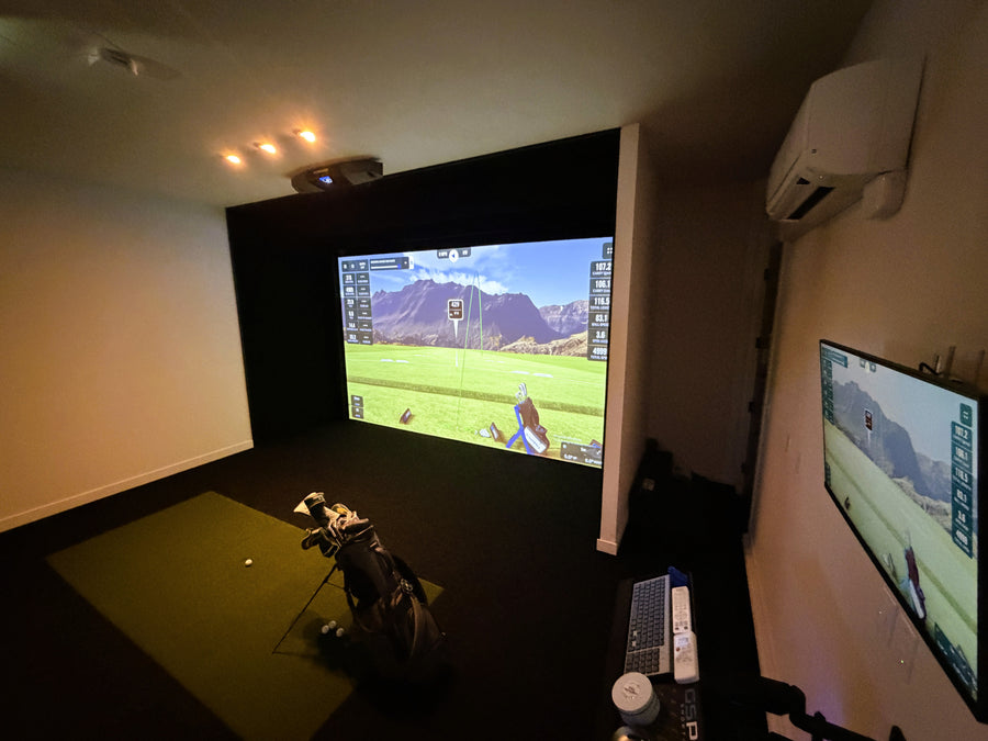 Golf simulator setup with two screens showing a golf course.