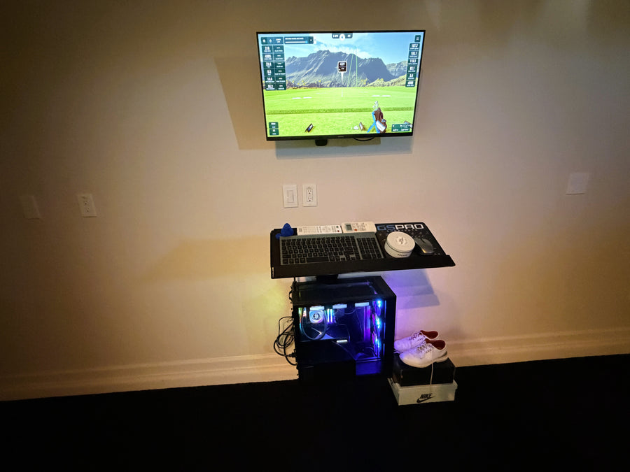 Golf Simulator gaming setup with TV displaying a golf game, keyboard, and mouse on a desk.
