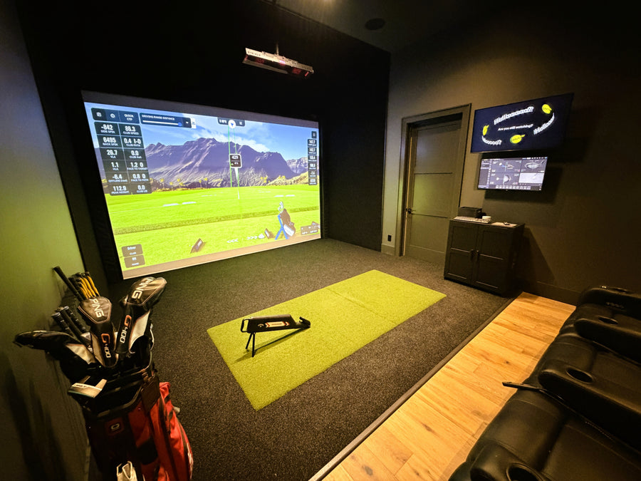 Golf simulator setup in a room with a screen displaying a golf course.