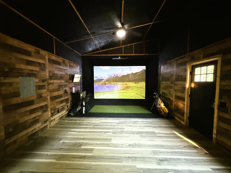 Indoor golf simulator setup in a room with wooden walls and floor.