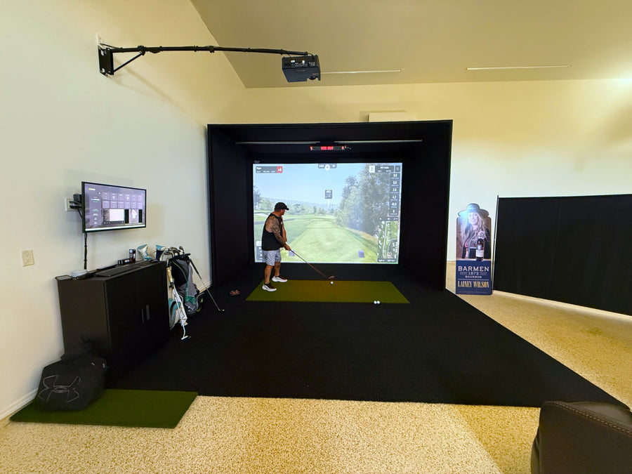 Indoor golf simulator setup with a screen displaying a golf game.
