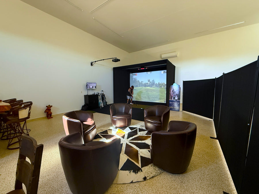 Modern garage with an indoor golf simulator, surrounded by stylish furniture.