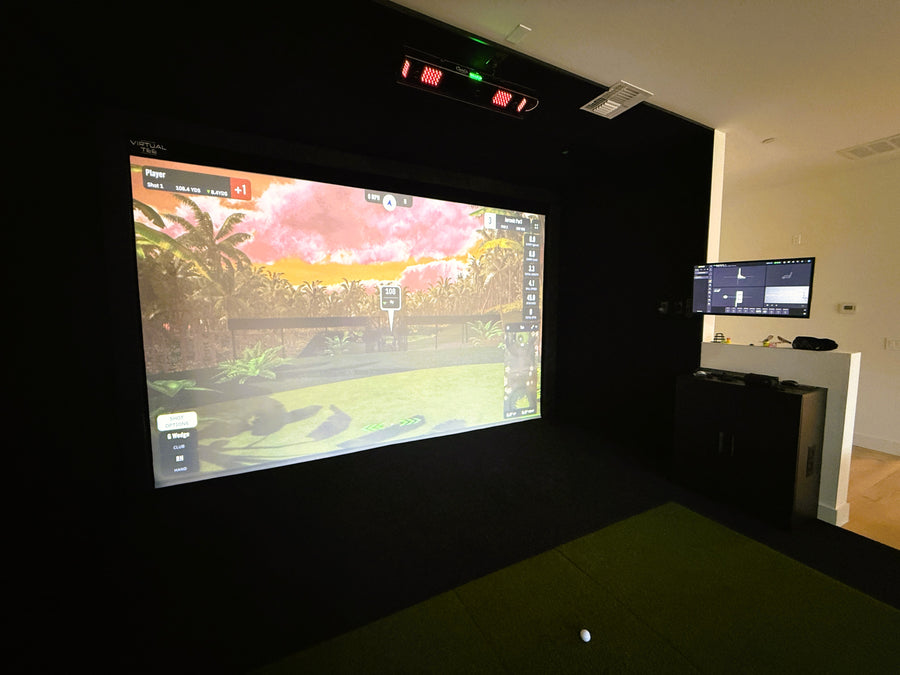Golf Simulator in a dark room with another smaller screen in the background.