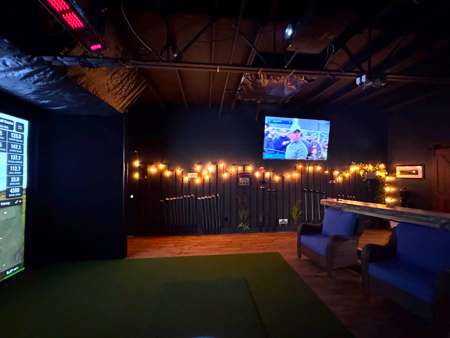 Side view of a golf simulator with accent wall, lighting, and seating