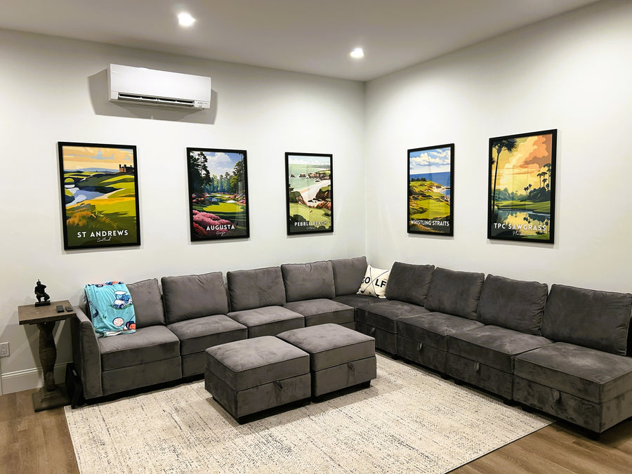 Gray sectional sofa in a living room with golf-themed wall art behind a golf simulator