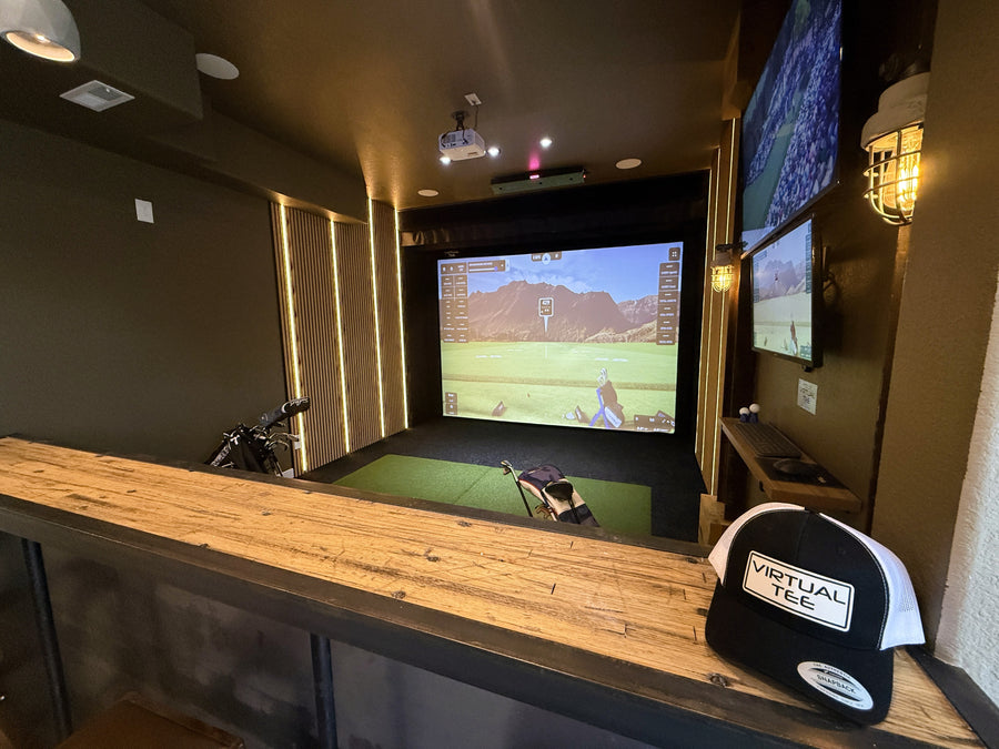 Indoor golf simulator setup with multiple screens.