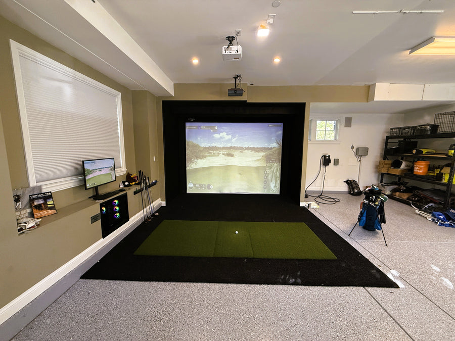 Indoor golf simulator setup in a home garage with screens and equipment.