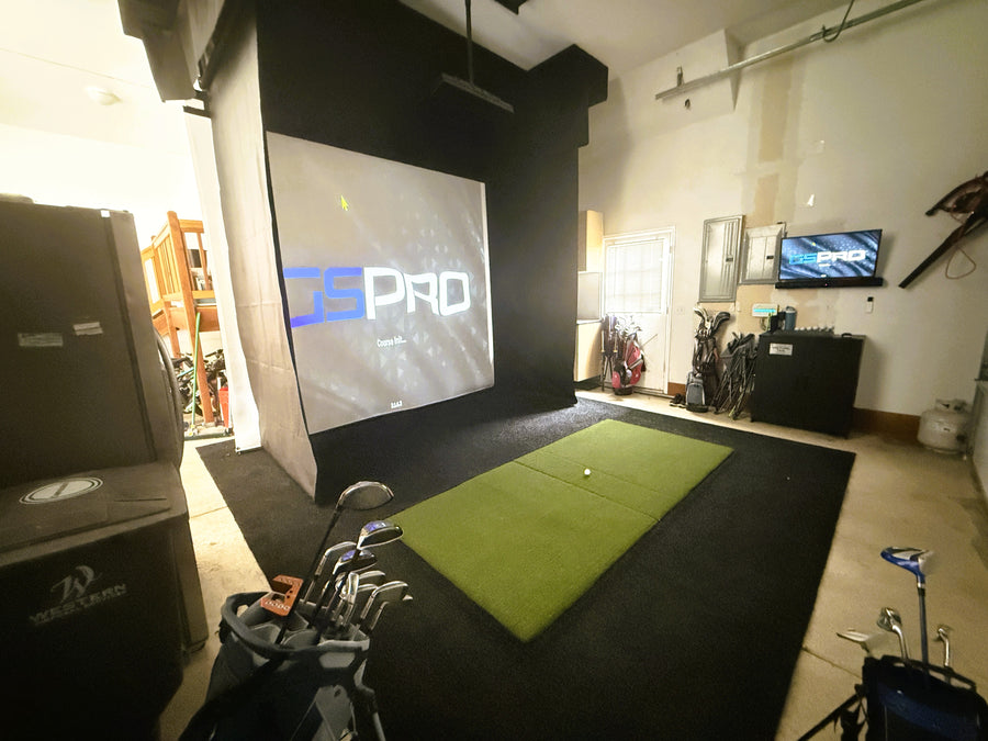 Golf simulator setup with screen displaying 'Golf Pro' and golf equipment on a mat.