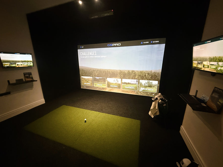 Indoor golf simulator setup with a screen displaying a golf course.