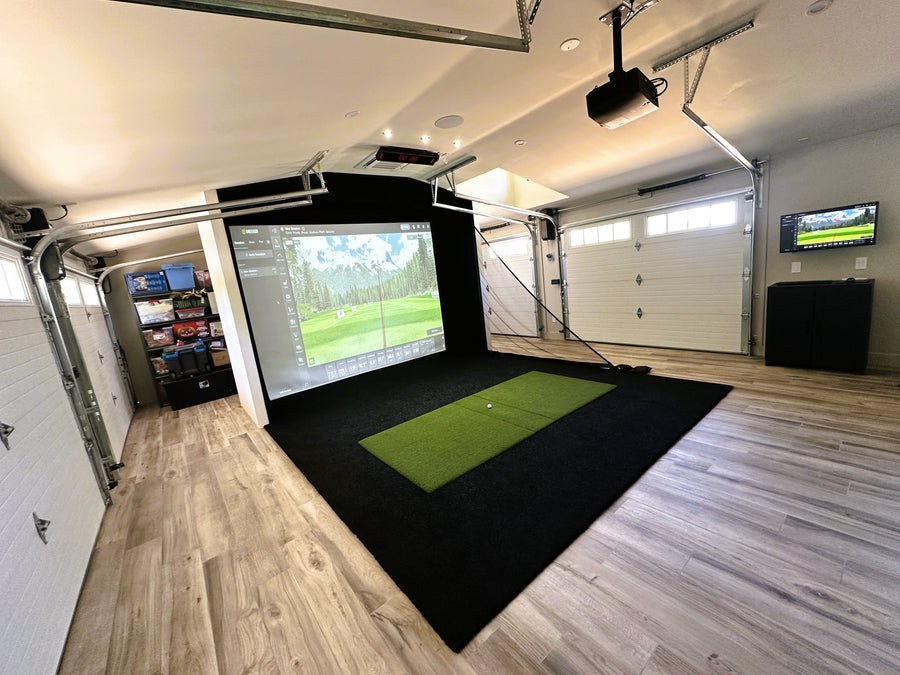 Golf simulator setup in a garage with a screen displaying a golf course.