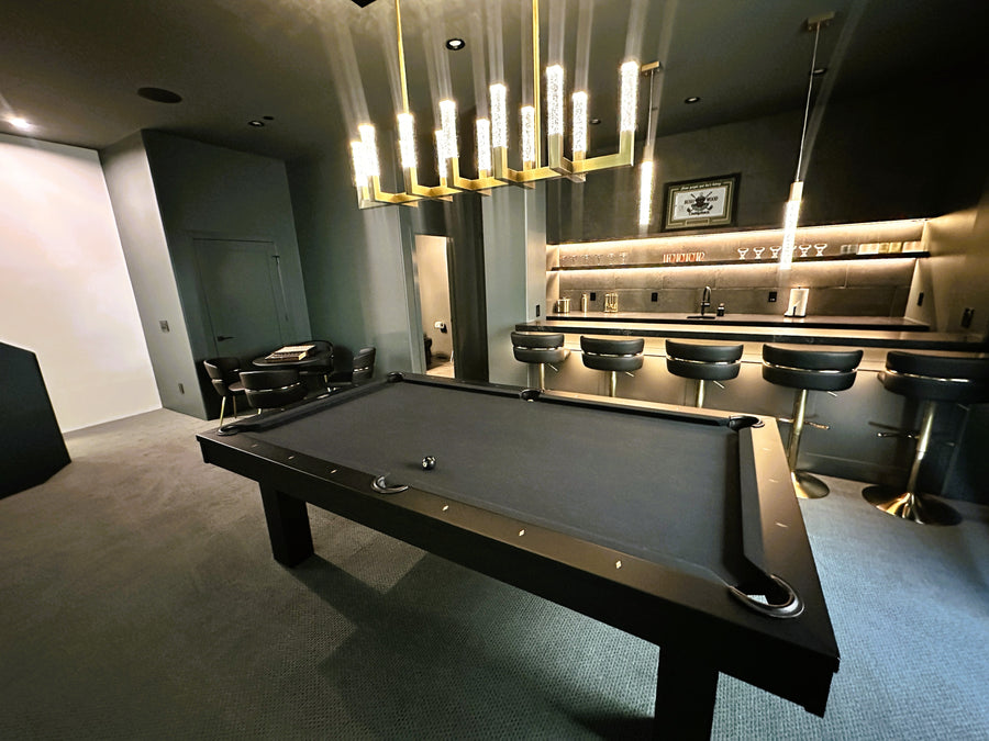 Modern billiards room with pool table, bar area, and golf simulator