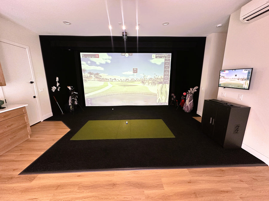 Indoor golf simulator setup with a screen displaying a golf course.
