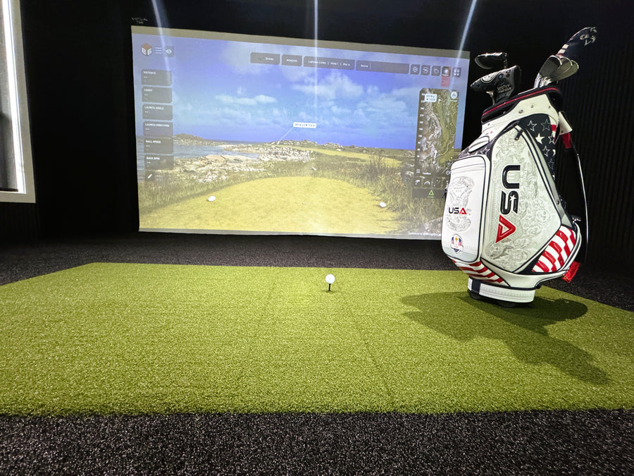 Golf simulator setup with golf bag and screen displaying a golf course.
