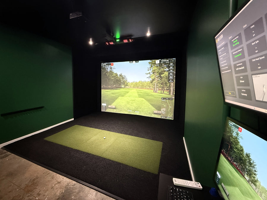 golf simulator installation featuring black turf and dual monitors.