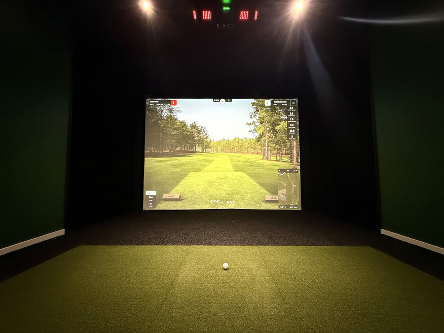 golf simulator setup featuring black turf with an inserted green hitting mat