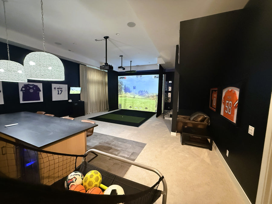 Modern golf simulator with a large screen displaying a sports game.