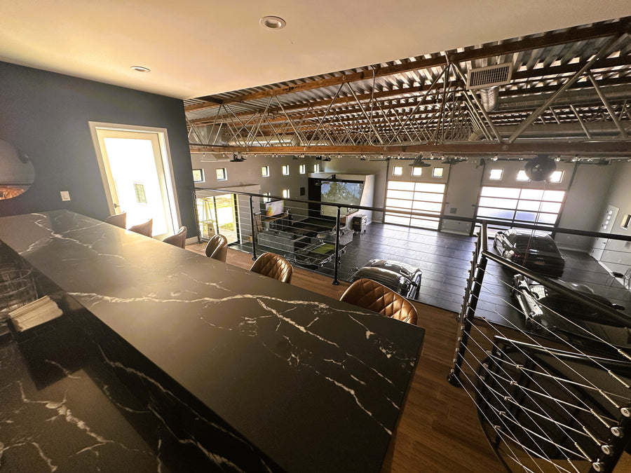 Modern kitchen with marble island over looking golf simulator.
