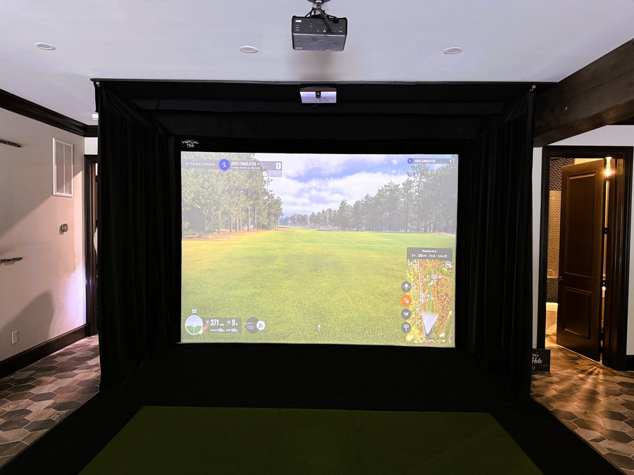 Indoor golf simulator setup with a screen displaying a golf course.