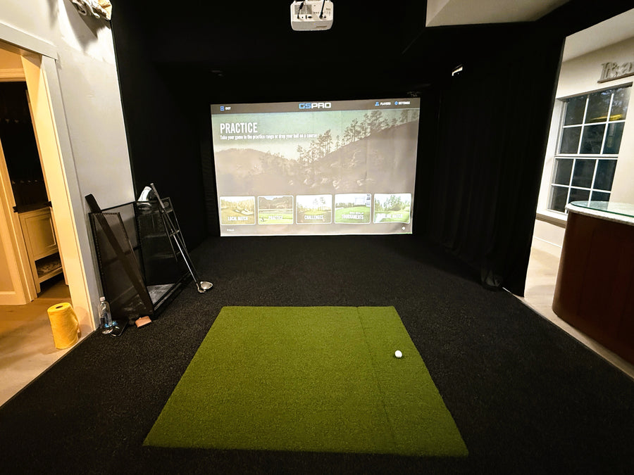 Golf simulator with a screen displaying a golf simulation game.
