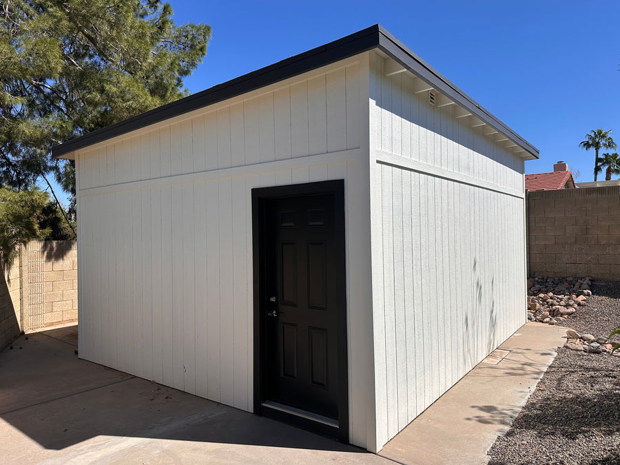 White storage shed with golf simulator inside.