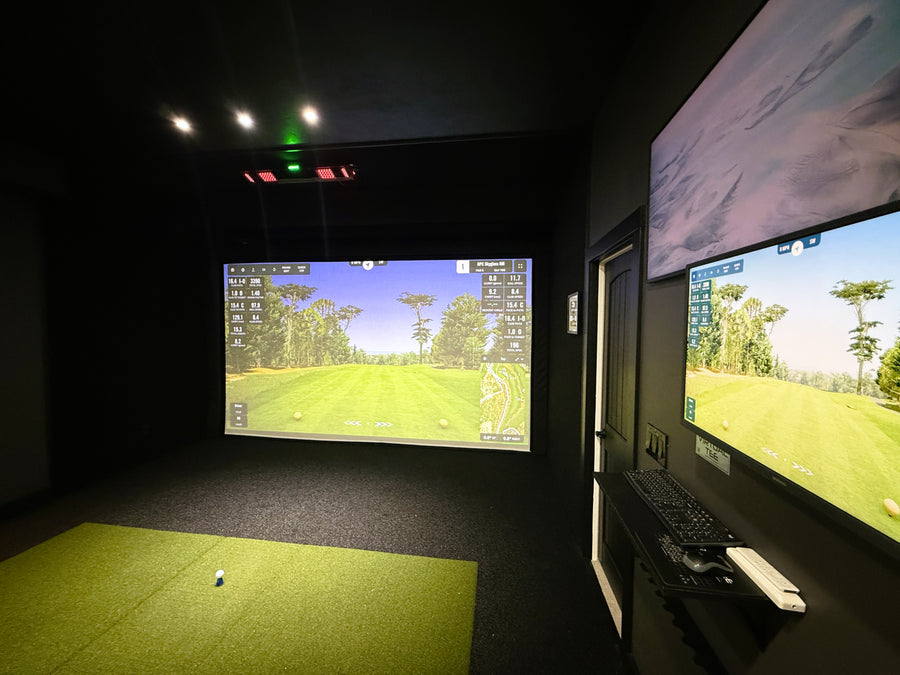 Golf simulator setup with two screens displaying a golf course.