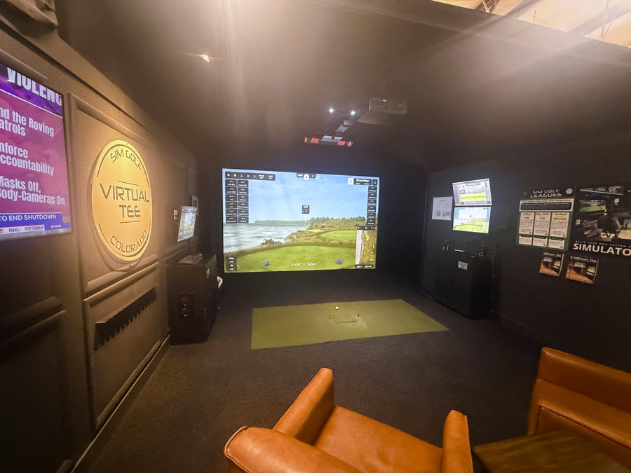 Golf simulator room with large screen and virtual tee branding.