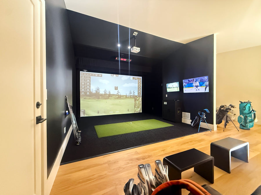 Indoor golf simulator setup with multiple screens and golf equipment in a room.
