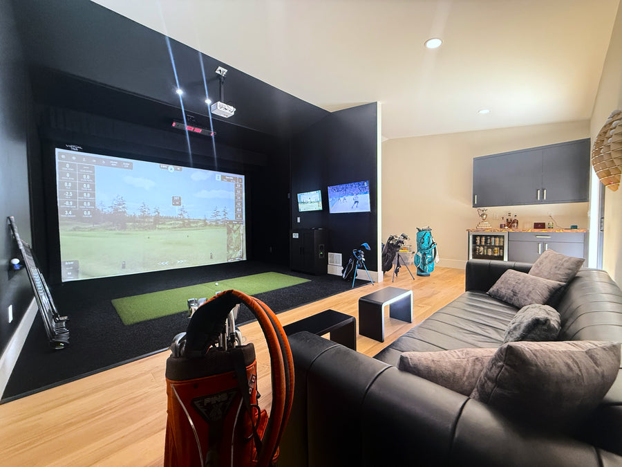Modern golf simulator room with a large screen displaying a video game, surrounded by furniture and decor.