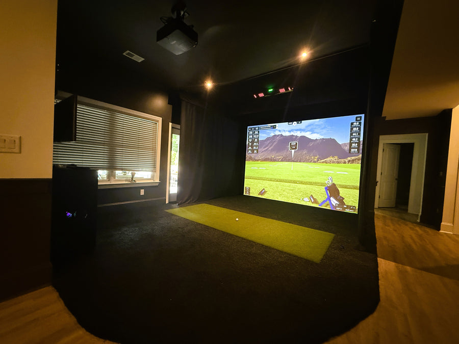 Indoor golf simulator with a large screen.