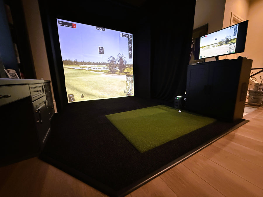 Golf simulator setup with two screens displaying golf courses.
